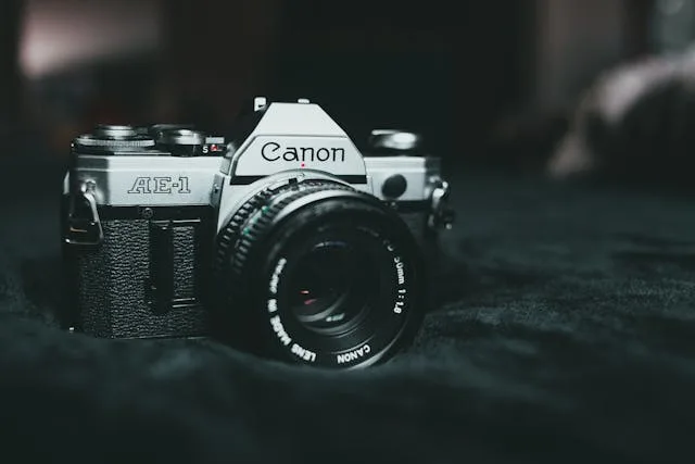 Classic Canon AE-1 Program 35mm film camera on black fabric