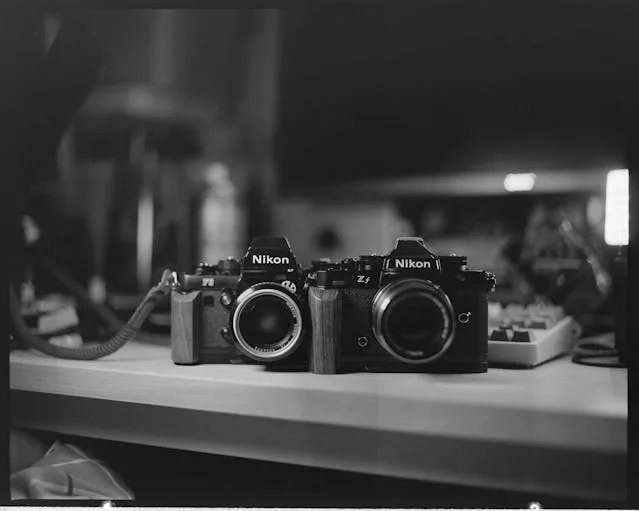 Nikon FE and FM2 film cameras side by side on a desk