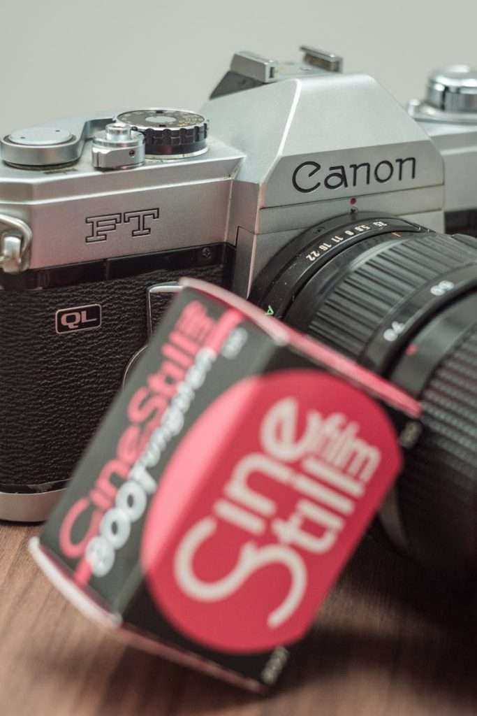Close-up of a vintage Canon camera paired with CineStill film roll, showcasing a retro photography setup.