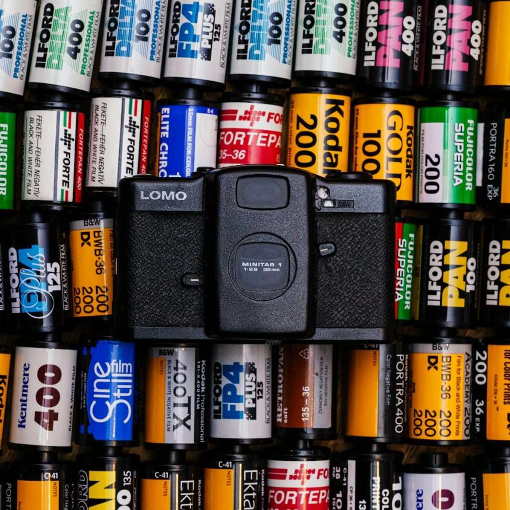 LOMO camera surrounded by diverse film roll brands, showcasing analog photography appeal.